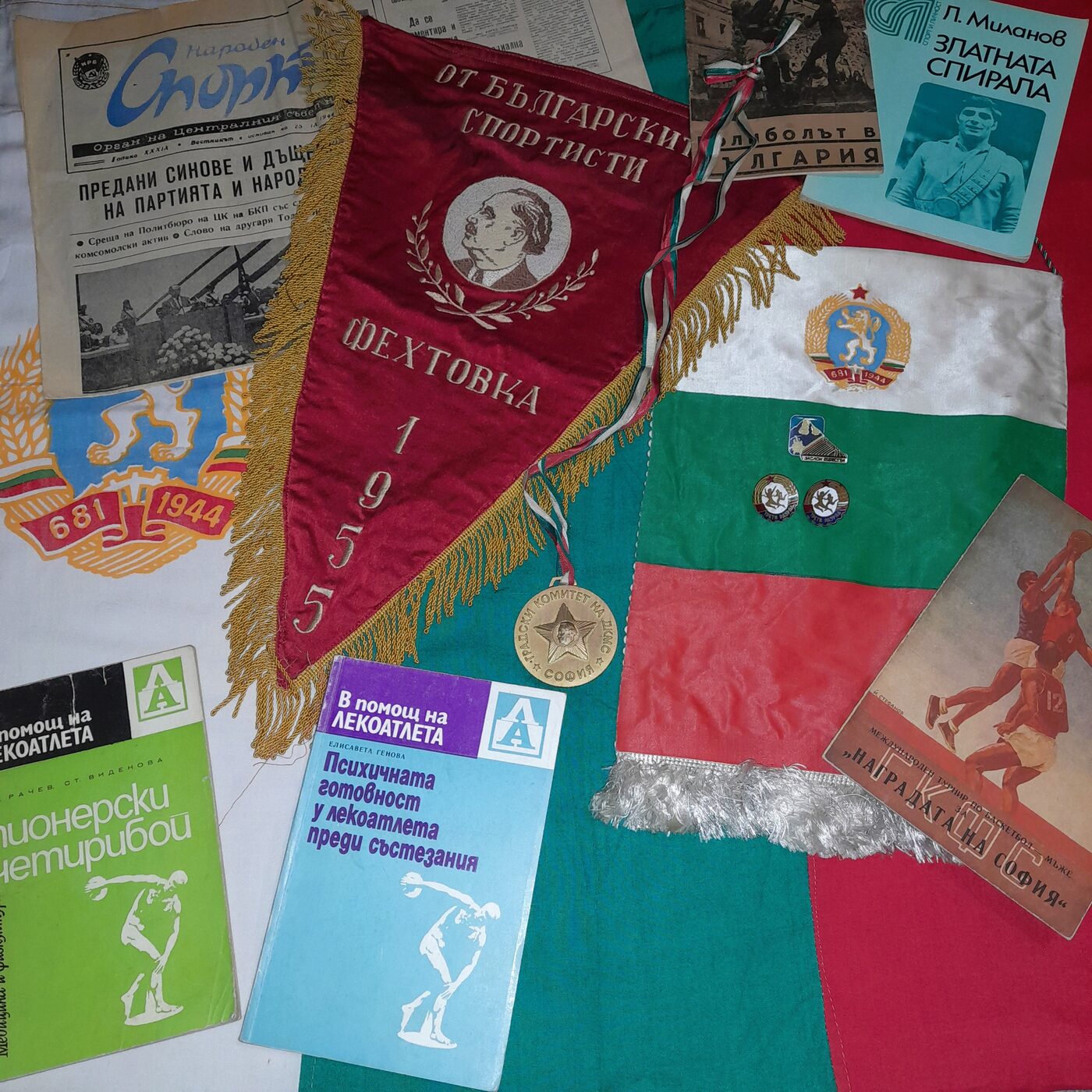 Objects of Bulgarian sport: fencing pennant from 1955, the newspaper Naroden Sport (Народен спорт), Sofia Komsomol medal, training manuals and competition programmes